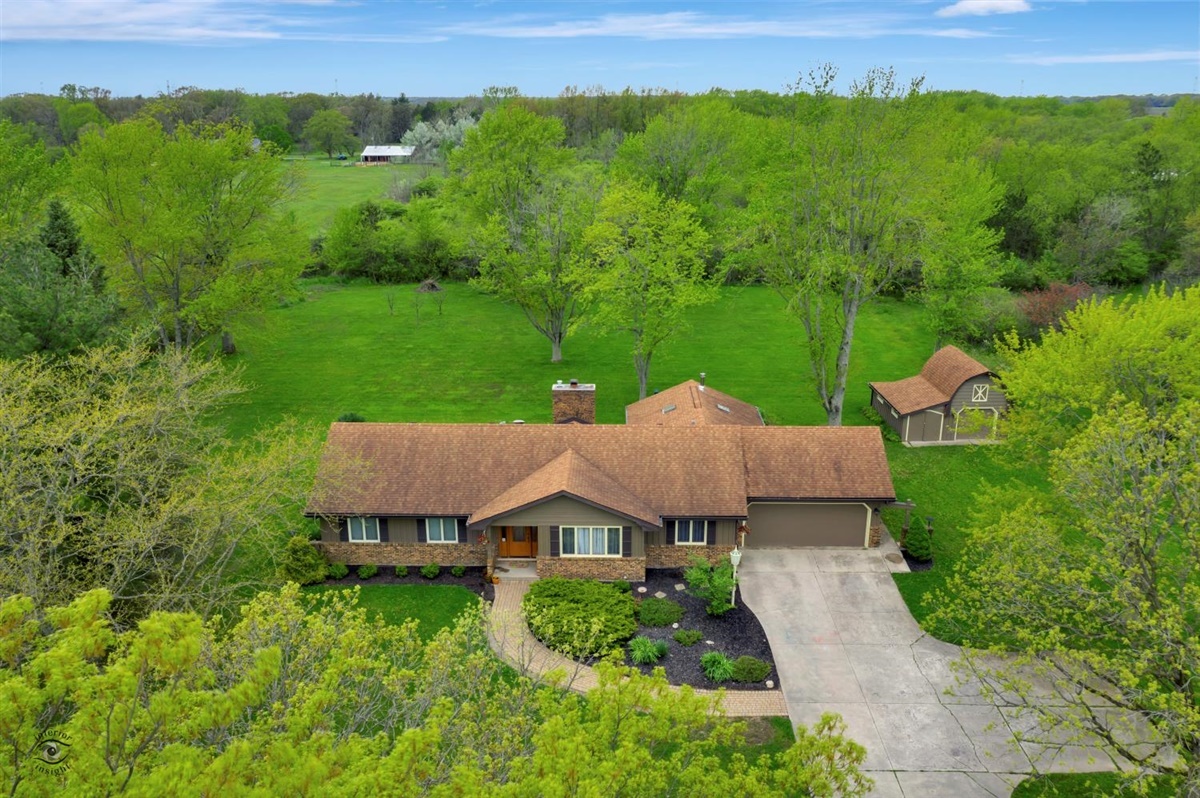 an aerial view of a house with yard and outdoor seating