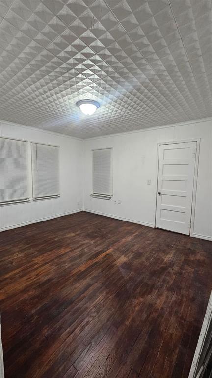 1007 Willow Street Bonham, TX 75418 - Photo 8 of 11 an empty room with wooden floor and cabinet