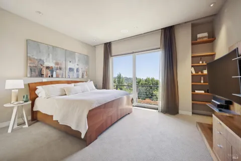 a bedroom with a bed flat screen tv and a large window