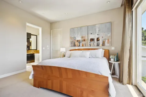 a bedroom with a bed and a painting on the wall