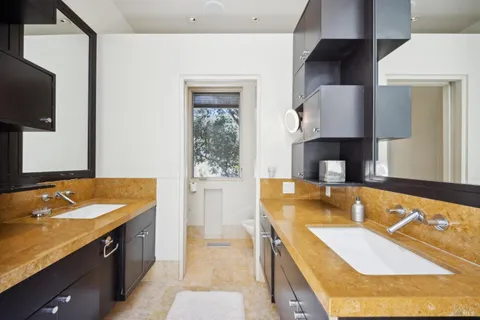 a bathroom with a granite countertop tub sink and mirror