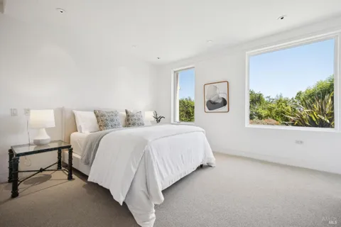 a spacious bedroom with a bed and a large window