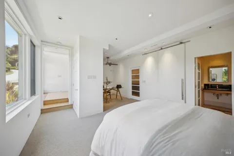 a bedroom with a bed and a large window