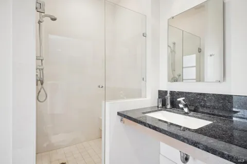a bathroom with a granite countertop sink and a mirror
