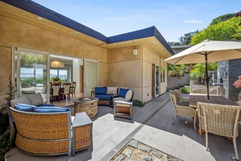 a living room with patio furniture and a potted plant