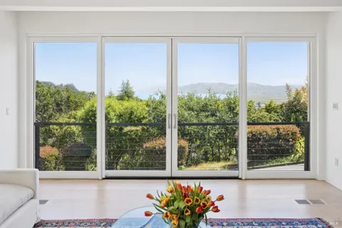 a view of a room that has a large window and front door