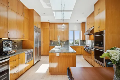 a large kitchen with stainless steel appliances kitchen island granite countertop a sink and cabinets