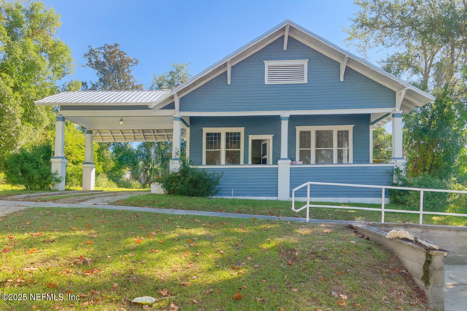 a view of a house with backyard and a tree