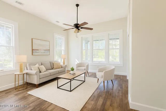 a living room with furniture a window and wooden floor