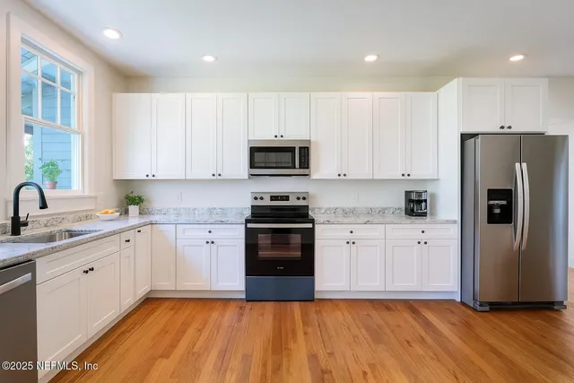 a kitchen with a sink a refrigerator a microwave and cabinets