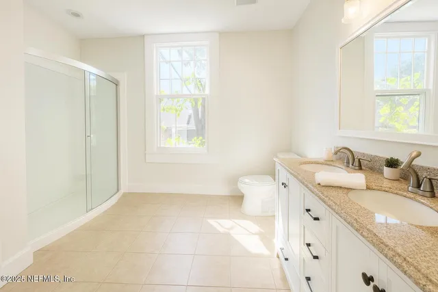 a bathroom with a granite countertop sink a mirror and a bathtub