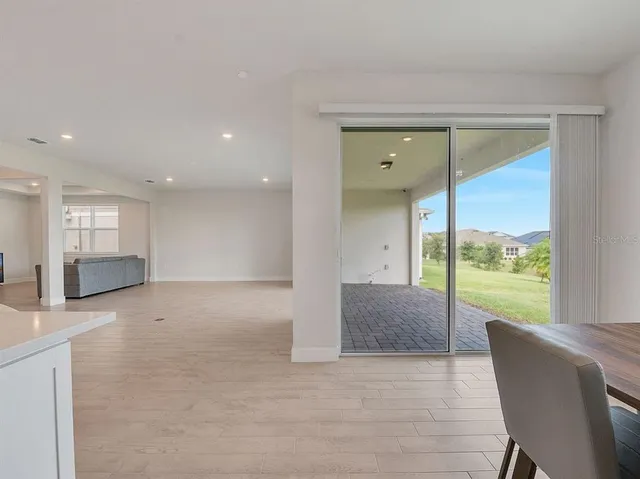 a view of an empty room with wooden floor and a glass door