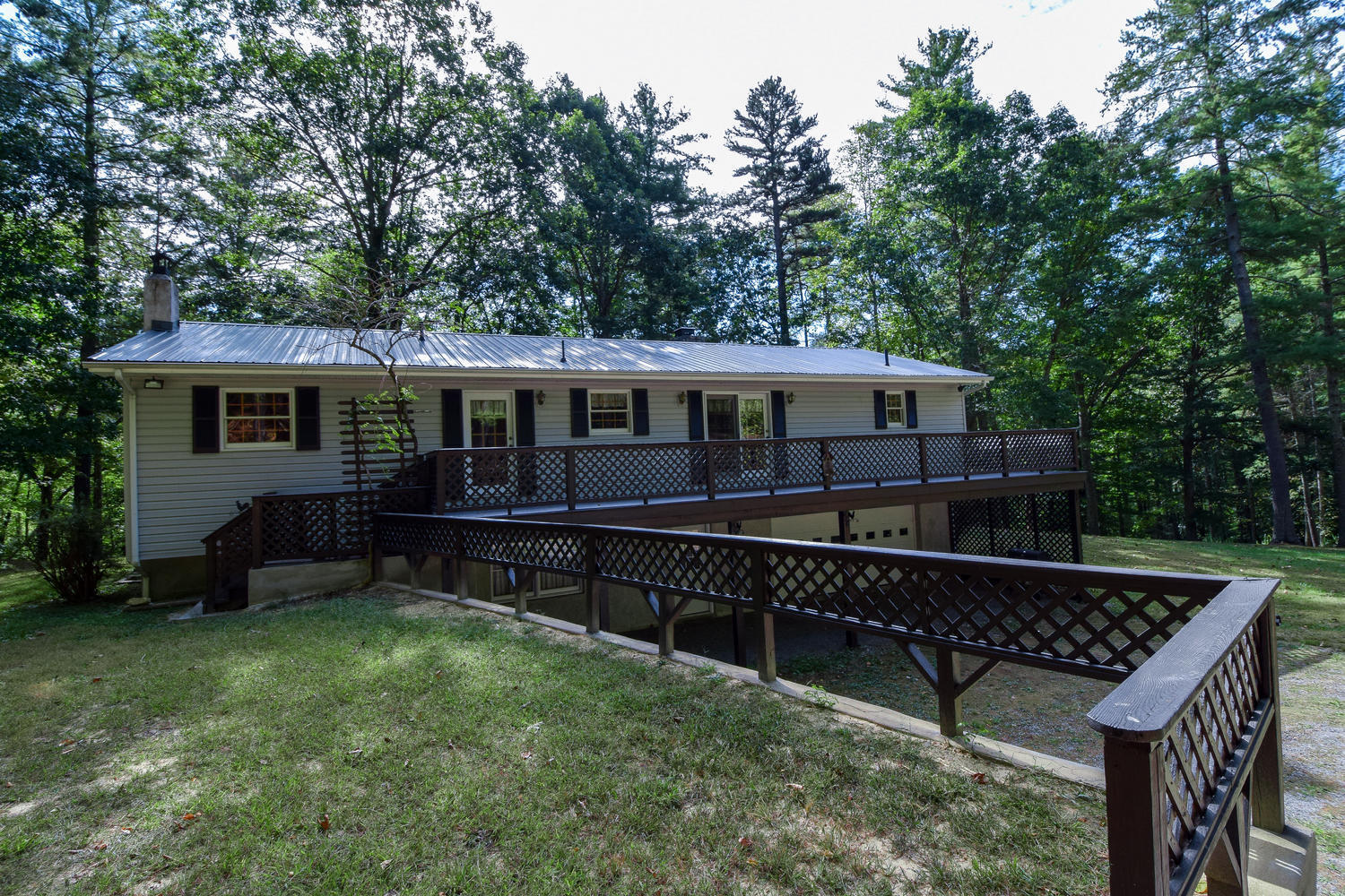 a view of house with a yard and sitting area
