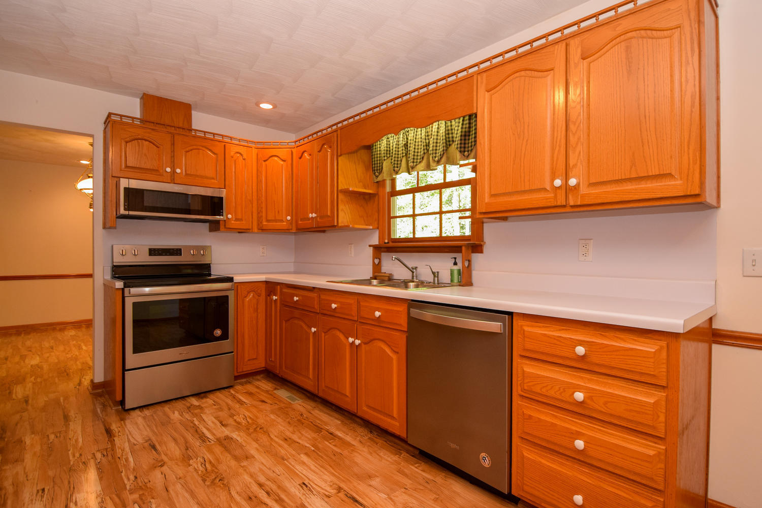16415 Paint Bank Road Paint Bank, VA 24131 - Photo 10 of 36 a kitchen with granite countertop wooden cabinets stainless steel appliances and a window