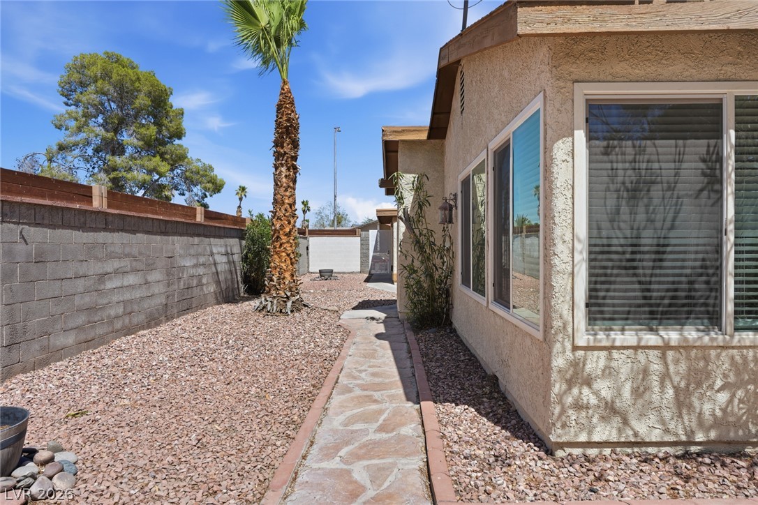 3971 Spring Leaf Drive Las Vegas, NV 89147 - Photo 25 of 48 A flagstone path winds alongside a stuccofinished residence, set amidst a low-maintenance gravel landscape.