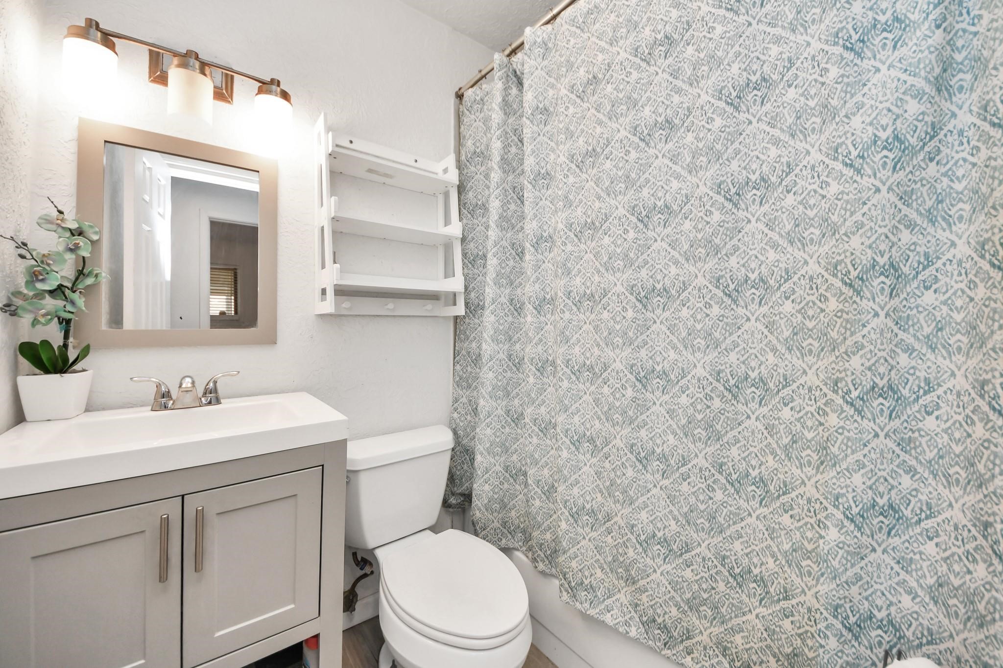 1415 Parry-Sound Pasadena, TX 77504 - Photo 18 of 34 a bathroom with a toilet sink vanity and mirror