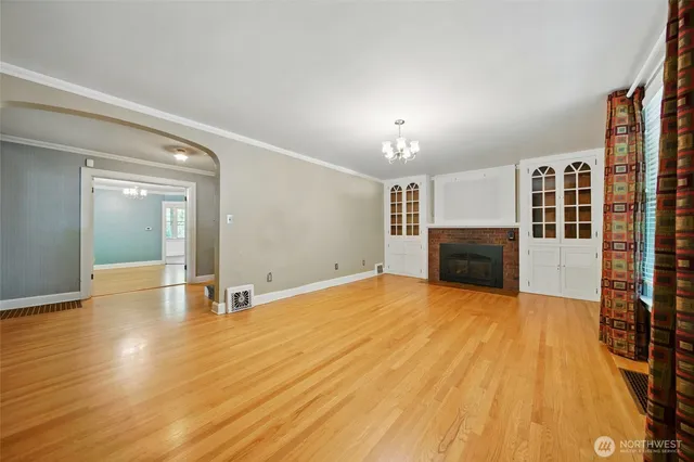 a view of empty room with wooden floor and fireplace