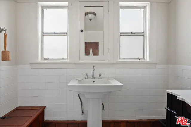 a bathroom with a sink a mirror and a window