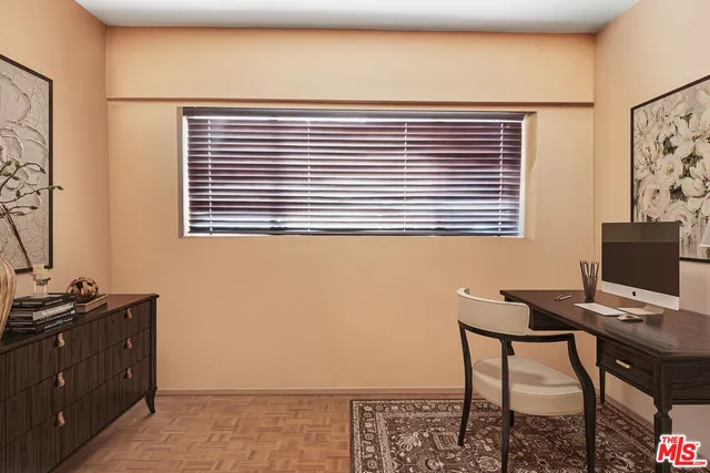 a view of a workspace with furniture and a window