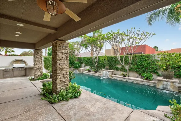 a kitchen with stainless steel appliances granite countertop a stove a refrigerator a kitchen island a table and chairs with wooden floor