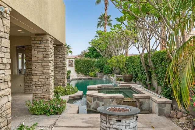 a kitchen with stainless steel appliances granite countertop a stove a refrigerator a kitchen island a table and chairs with wooden floor