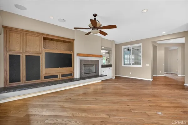 an empty room with a window and a fan