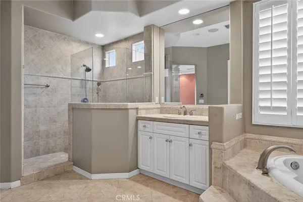 a view of a livingroom with a chandelier fan and windows