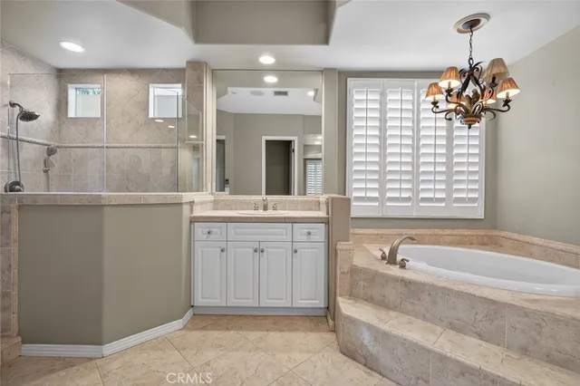 a view of a livingroom with a chandelier fan and windows