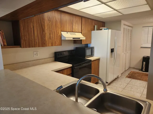 a kitchen with cabinets and a refrigerator