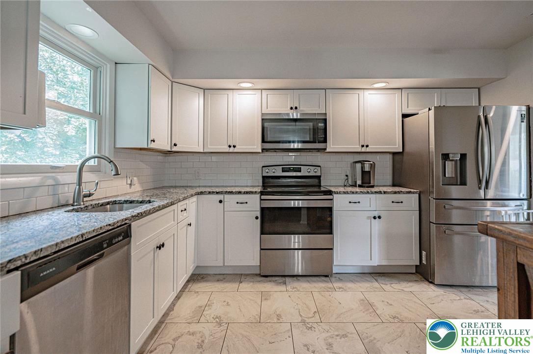 7523 Franks Drive Bath, PA 18014 - Photo 17 of 40 a kitchen with stainless steel appliances granite countertop a refrigerator sink and stove