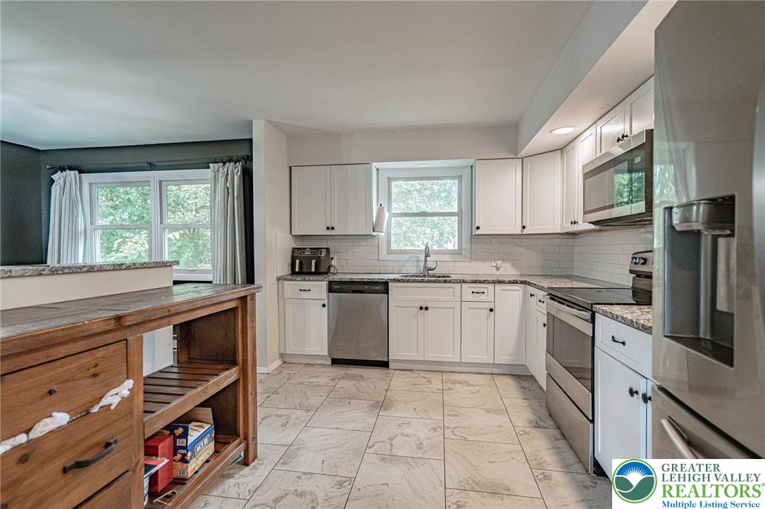 7523 Franks Drive Bath, PA 18014 - Photo 19 of 40 a kitchen with stainless steel appliances a stove sink and cabinets