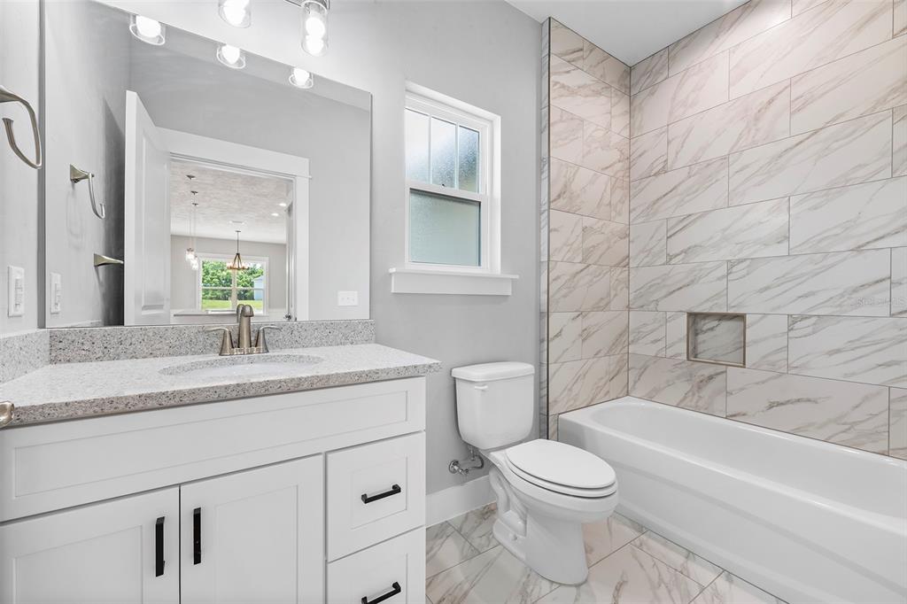 0 Southwest Meadow View Lake City, FL 32024 - Photo 20 of 31 a bathroom with a granite countertop sink toilet a large mirror a bathtub and shower