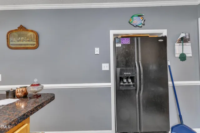 a hallway with painting and a refrigerator