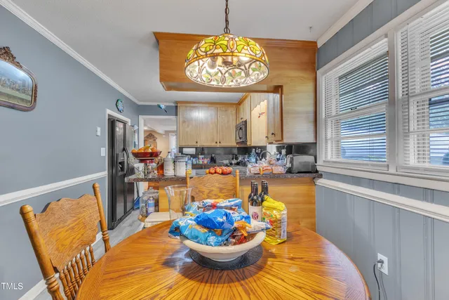 a view of a dining room with furniture a chandelier and wooden floor