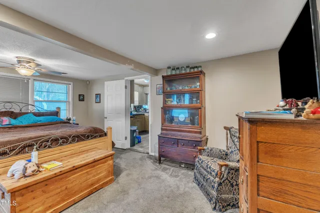 a spacious bedroom with a bed and a flat screen tv