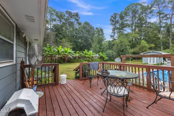 a view of a patio with table and chairs with wooden floor and fence