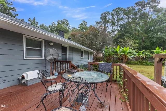 a view of backyard with swimming pool and seating space