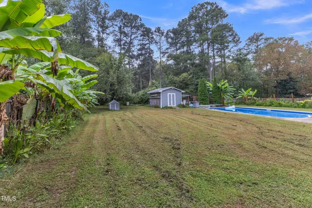 a backyard of a house with lots of green space and fountain