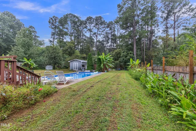 a view of a house with swimming pool next to a yard