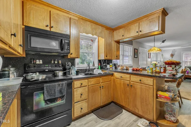 a kitchen with stainless steel appliances granite countertop a stove a sink and a microwave