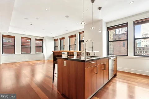 a kitchen with stainless steel appliances granite countertop wooden floors and sink
