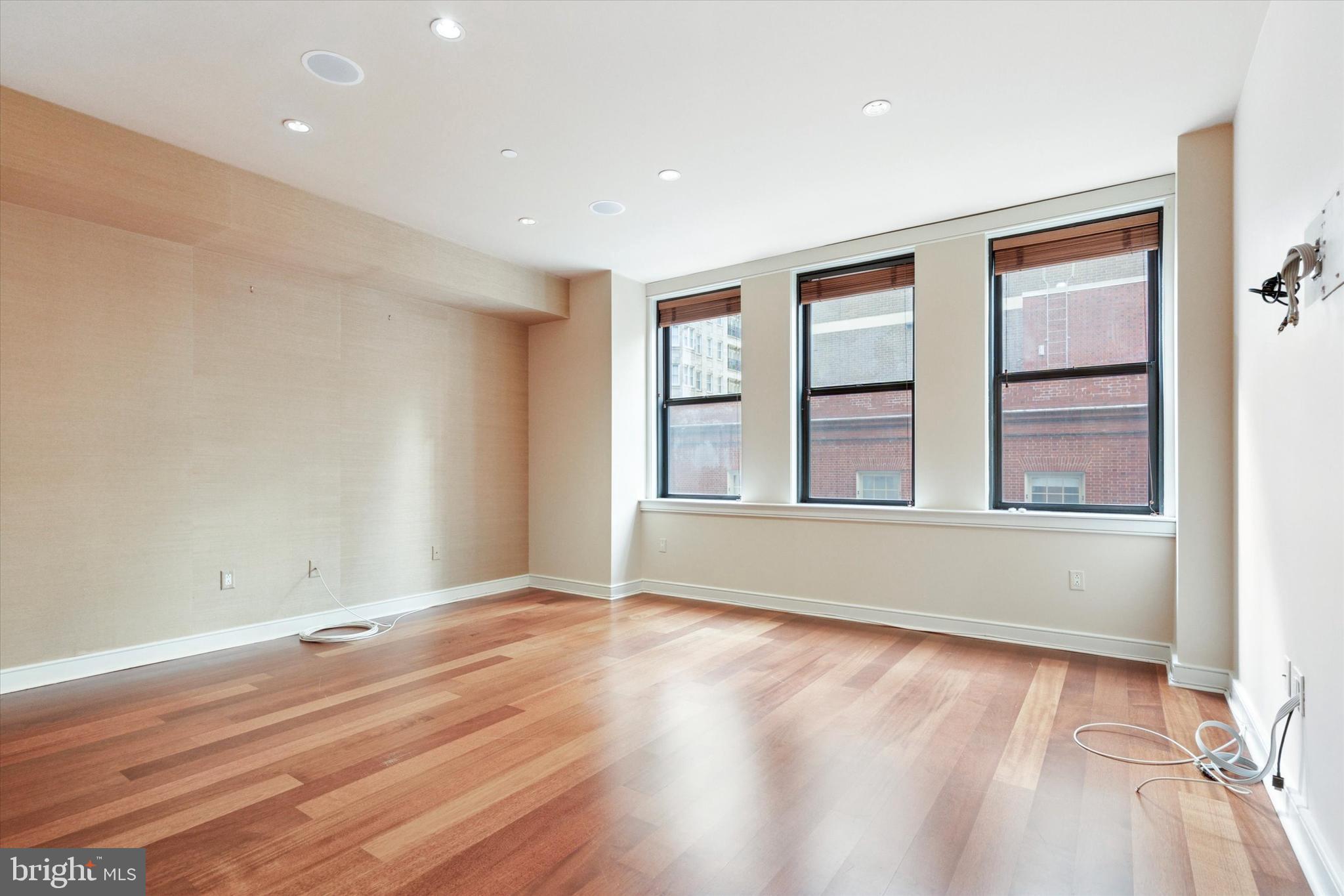 1515 Locust Street, Unit 400 Philadelphia, PA 19102 - Photo 12 of 25 an empty room with wooden floor and windows