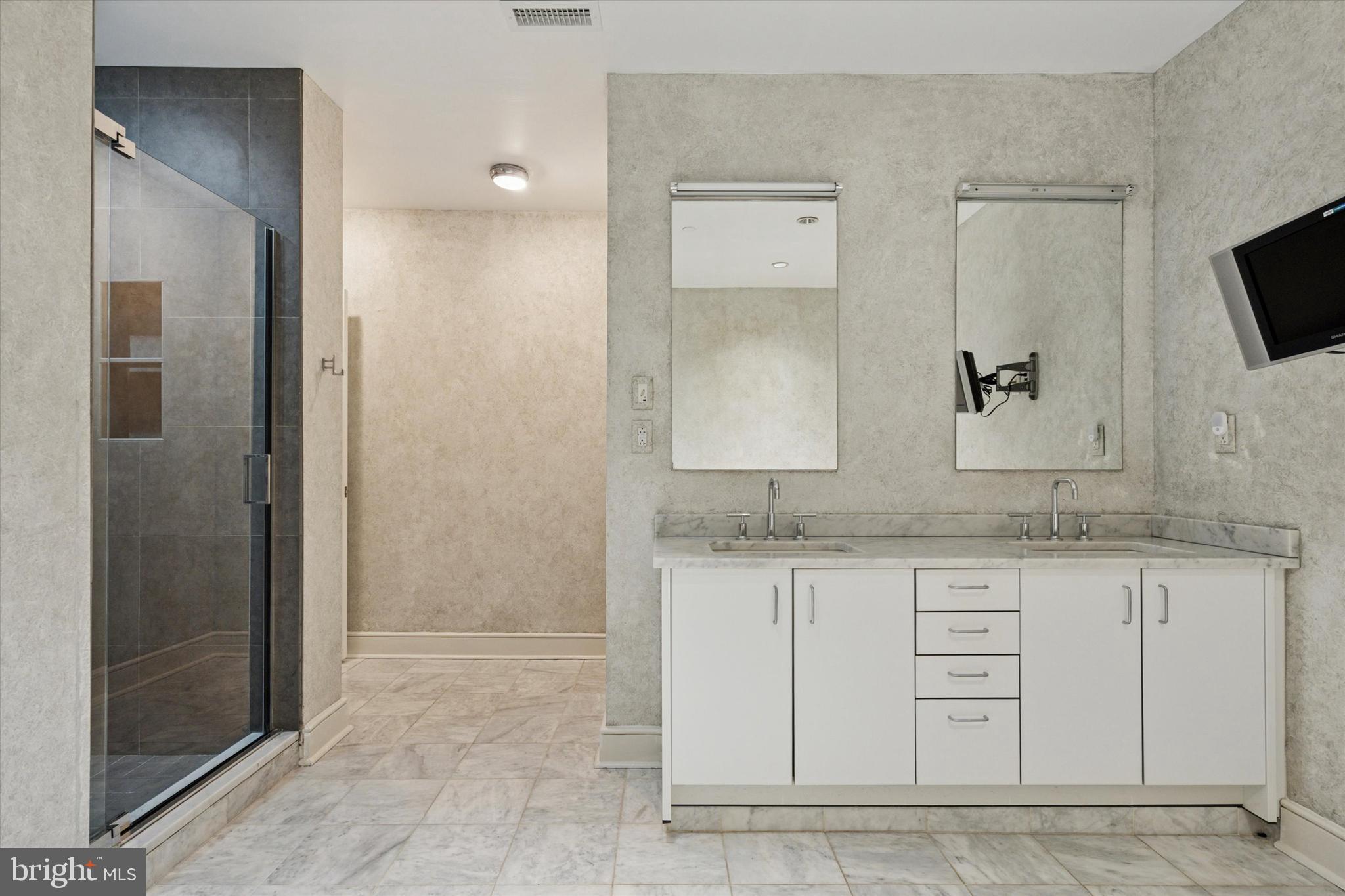 1515 Locust Street, Unit 400 Philadelphia, PA 19102 - Photo 16 of 25 a bathroom with a granite countertop sink and a mirror