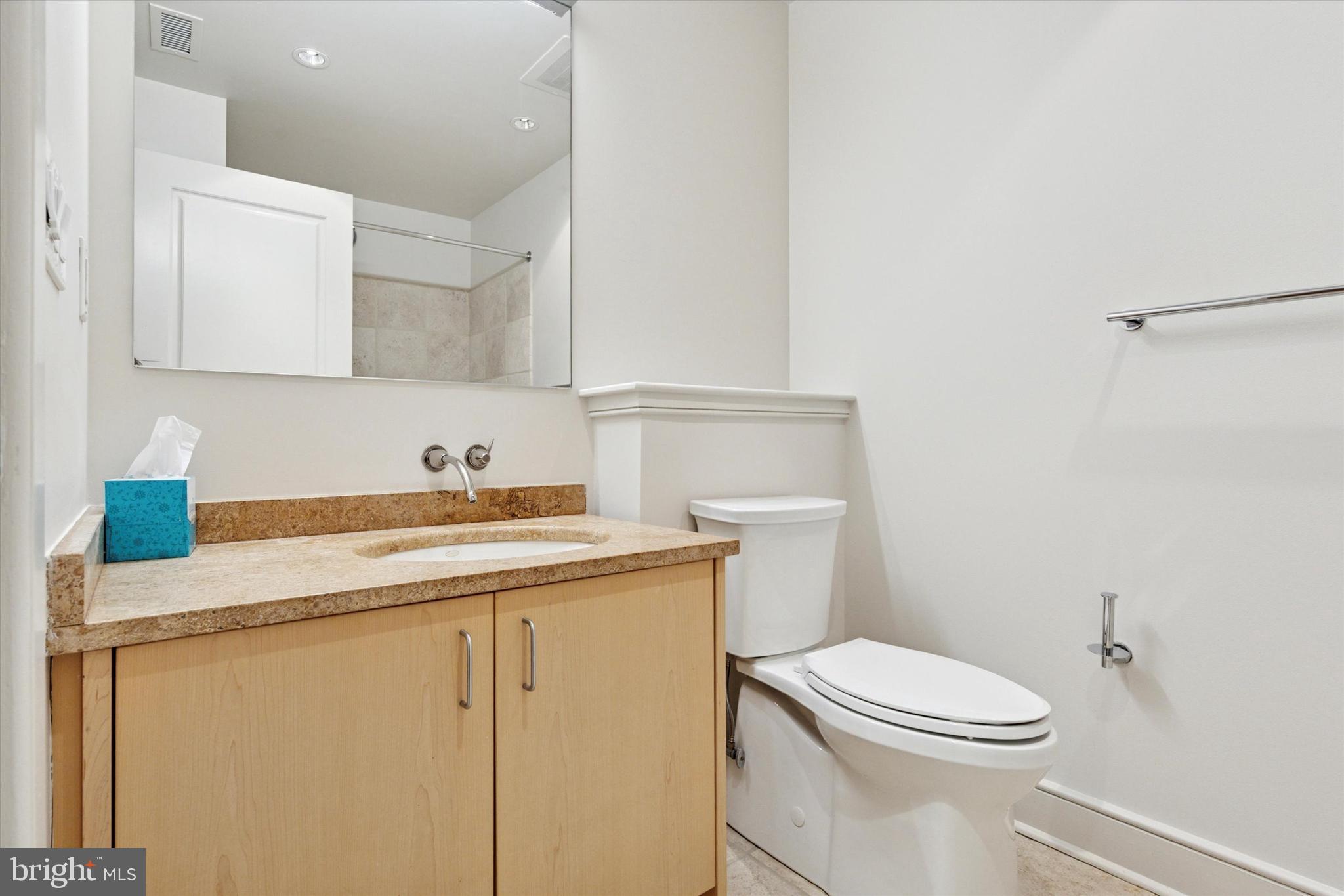 1515 Locust Street, Unit 400 Philadelphia, PA 19102 - Photo 23 of 25 a bathroom with a sink a toilet and mirror