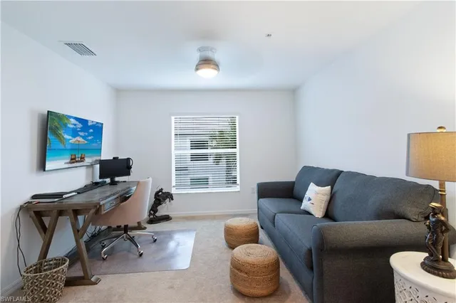 a livingroom with workspace couch and a window