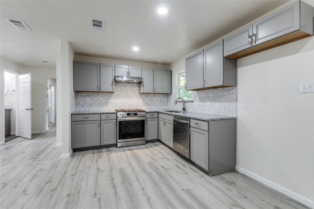 2908 Scottsbluff Drive Dallas, TX 75228 - Photo 7 of 34 a kitchen with a white cabinets a sink and wooden floor