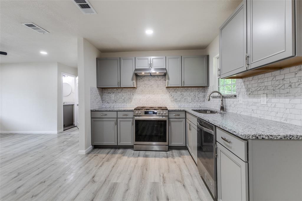 2908 Scottsbluff Drive Dallas, TX 75228 - Photo 8 of 34 a kitchen with stainless steel appliances granite countertop a stove a sink and a microwave