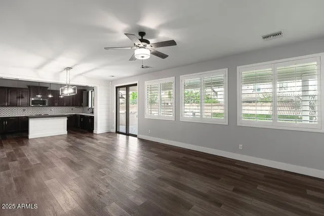 a view of a kitchen with a stove cabinets a ceiling fan and wooden floor