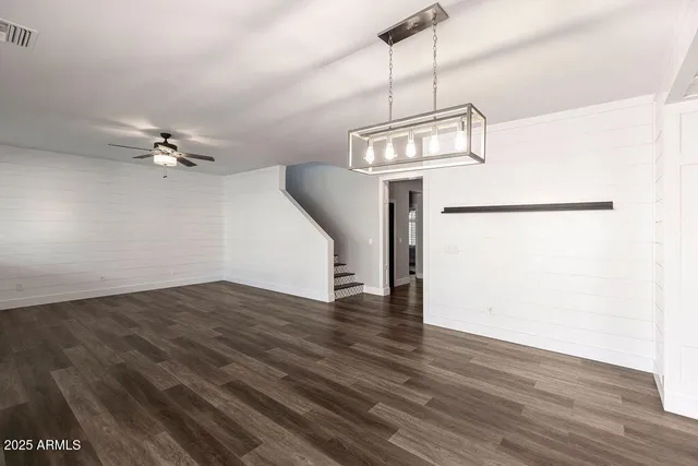 a view of a room with wooden floor and ceiling fan
