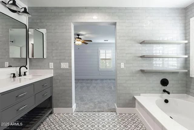 a bathroom with a bathtub shower sink vanity and toilet
